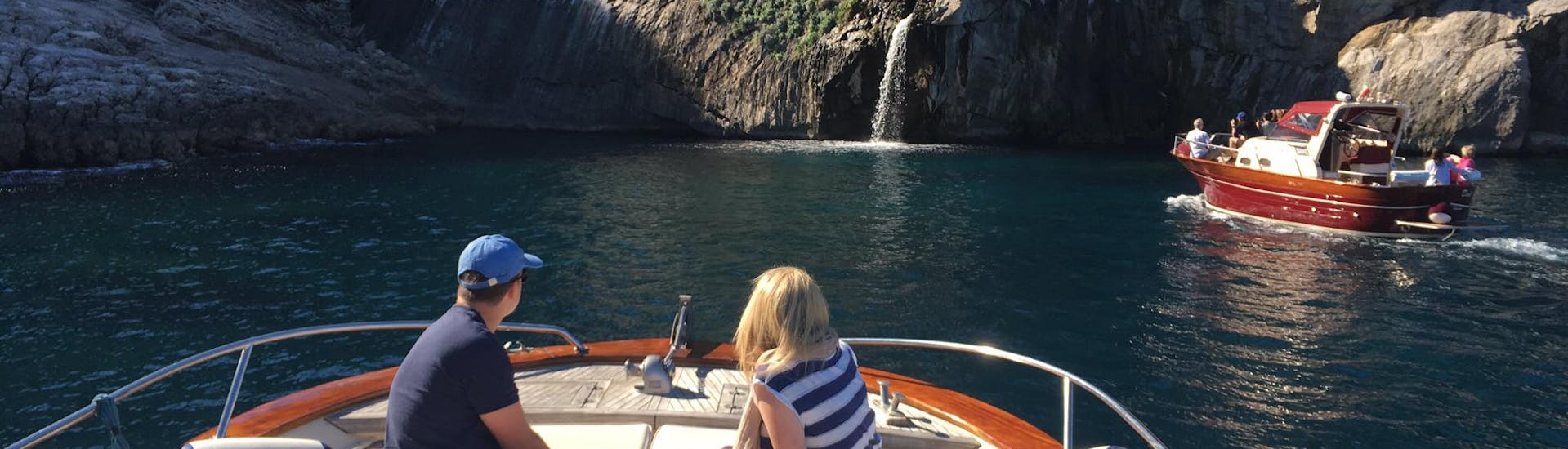 Een koppel poseert voor een foto achter de Faraglioni rotsen tijdens de boottocht van Sorrento naar Capri inclusief Blue Grotto met Lubrense Boats Costiera Amalfitana.