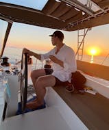 Un huésped de Spiridakos Sailing Cruises disfruta de su tiempo en un catamarán durante un crucero privado al atardecer por los lugares de interés de Santorini.