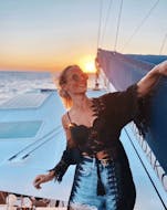 Eine Frau genießt die Private Bootstour bei Sonnenuntergang mit Vulkan-Wanderung mit Spiridakos Sailing Cruises Santorini.