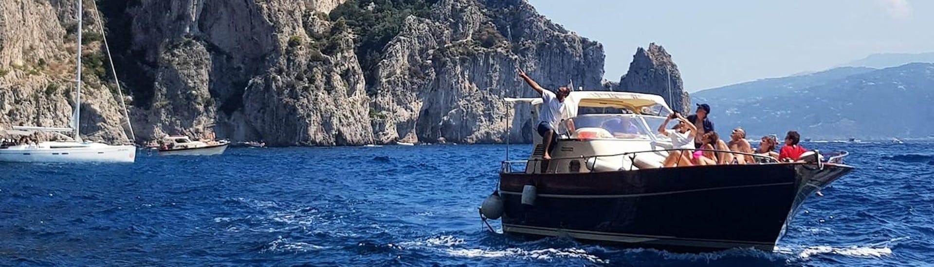 Un des bateaux rempli d'un groupe de gens joyeux pendant une balade en bateau de Sorrente à Positano et Amalfi avec Lubrense Boats Costiera Amalfitana.