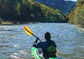 11km Kayak & Canoe on Tarn River in Sainte-Énimie - Wild from Canoë La Cazelle Gorges du Tarn A tourist in his kayak is watching the beautiful landscapes under the sun during the Wild tour of 12km Canoe Rental on the Tarn with Canoe La Cazelle Gorges du Tarn.