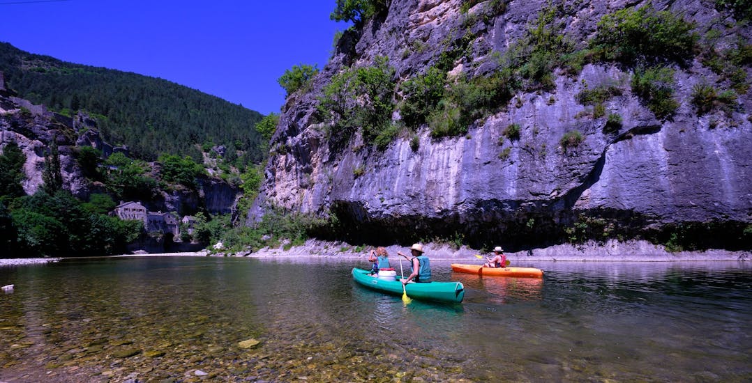 A group of tourist are paddling in the Gorges during the Classic Tour of 12km Canoe Rental on the Tarn with Canoe La Cazelle Gorges du Tarn.