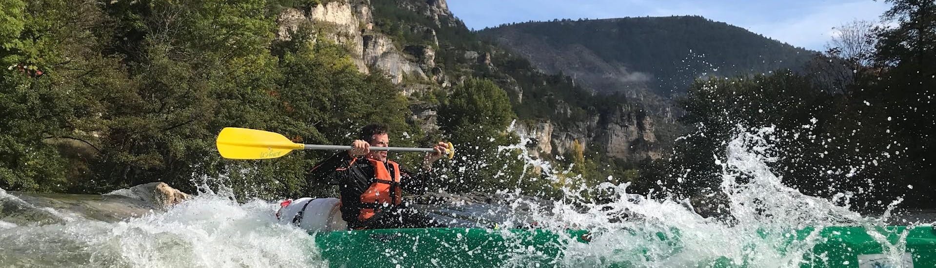 Een man peddelt actief in het hart van de Gorges tijdens de sportieve tocht van 20 km Kano verhuur op de Tarn met Kano La Cazelle Gorges du Tarn.