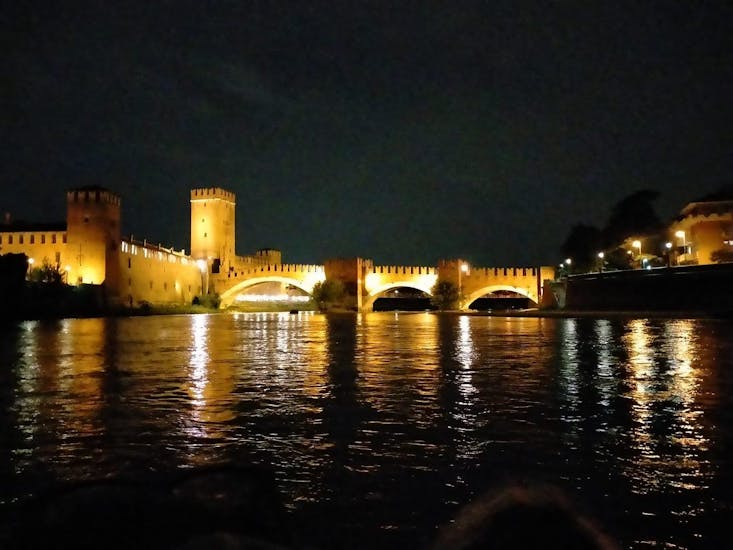 The rafting tour is passing under a bridge during the Moonlight Rafting on the Adige River through Verona with Pescantina Rafting Bussolengo.