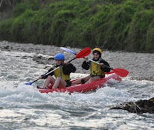 Dos amigos se divierten mucho durante el Kayak en el río Adige en la Terra dei Forti con Pescantina Rafting Bussolengo.