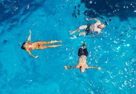 A group of friends is swimming in crystal clear water during the Boat Trip along the San Vito Lo Capo Coast with Mare and More Trapani.