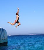 Una mujer salta desde el barco de Magic Catamarans al agua durante su recorrido en catamarán por la bahía de Palma de Mallorca.