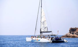 Le catamaran de Catamarans Sensations navigue sur les eaux bleues de la Costa Brava pendant la Sortie en catamaran sur la Costa Brava avec Snorkeling.