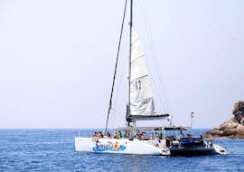 The catamaran from Catamaran Sensations is sailing across the blue waters of the Costa Brava during the Catamaran Trip along Costa Brava with Swimming & Snorkeling.