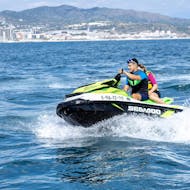 Two people are riding a jet ski from Sea Riders Badalona  while doing a tour around the Barcelona Bay area.