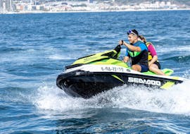 Two people are riding a jet ski from Sea Riders Badalona  while doing a tour around the Barcelona Bay area.