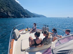 Un grupo de amigos disfrutando del viaje en barco privado de un día completo a Cinque Terre y Golfo dei Poeti con Fish & Chill Cinque Terre Tour.