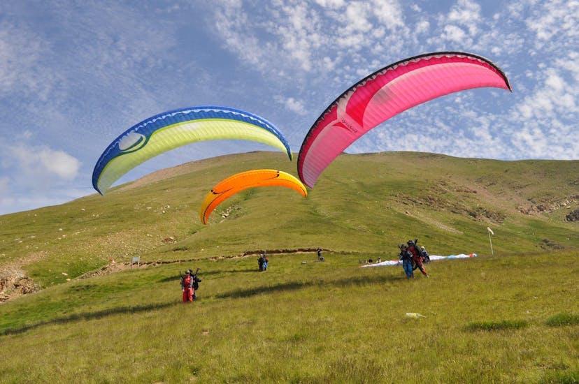 Three people are taking off with the paragliding with Parapente Pirineos in the village of Castejón de Sos.