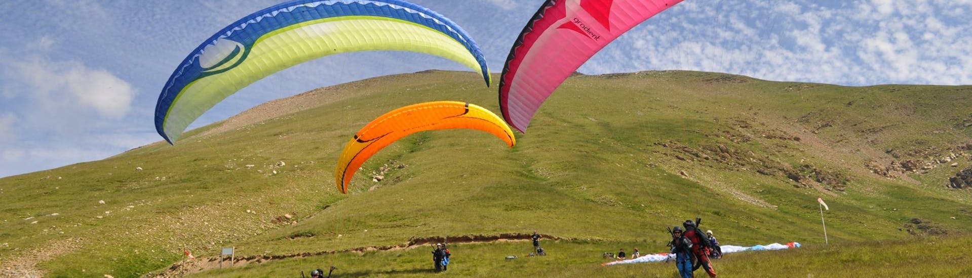 Trois personnes s'envolent pour leur vol Tandem Parapente dans le val d'Arán - Vol panoramique avec Parapente Pirineos dans le village de Castejón de Sos.