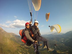 Two people are paragliding in a Tandem Panorama Flight with Parapente Pirineos in Aran Valley.