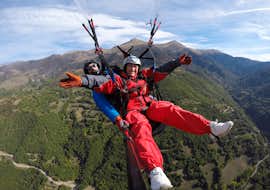 Tandem Paragliding in Benasque Valley - High Altitude Flight with Parapente Pirineos. Two people smile at the camera while doing paragliding in a tandem high altitude flight with Parapente Pirineos in Aran Valley.