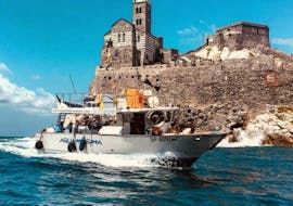 During the boat trip along the Cinque Terre with Fish Barbecue, the boat from Aquamarina Cinque Terre can be seen cruising past an old church.