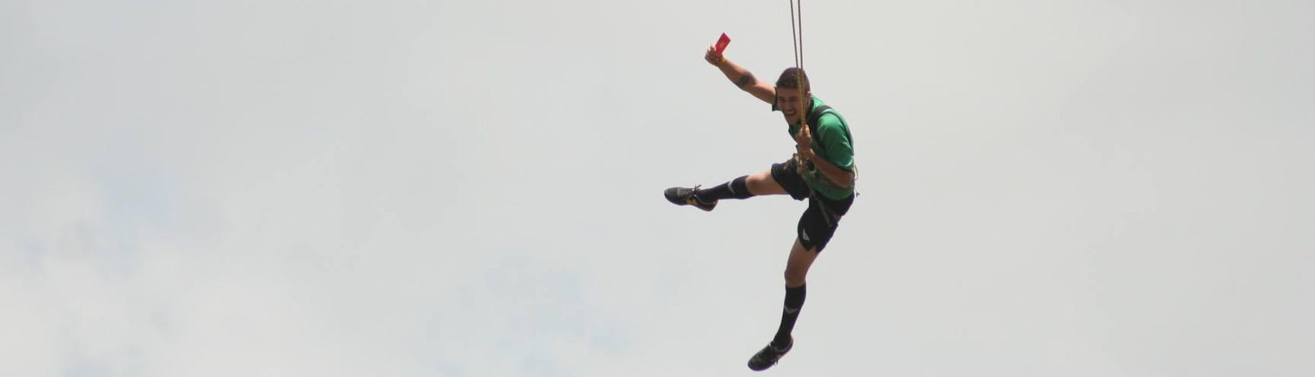 Un hombre practica un salto de puenting en Almovódar del Río con Vivak Nature.