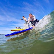 Een familie oefent samen in de zee tijdens de surflessen op het strand van Cavaliers voor gezinnen met Gliss'Experience Anglet.