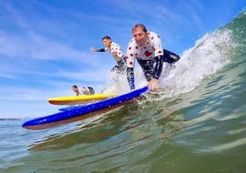 Eine Familie übt gemeinsam das Surfen im Meer beim Surfunterricht für Familien am Cavaliers Beach mit Gliss'Experience Anglet.