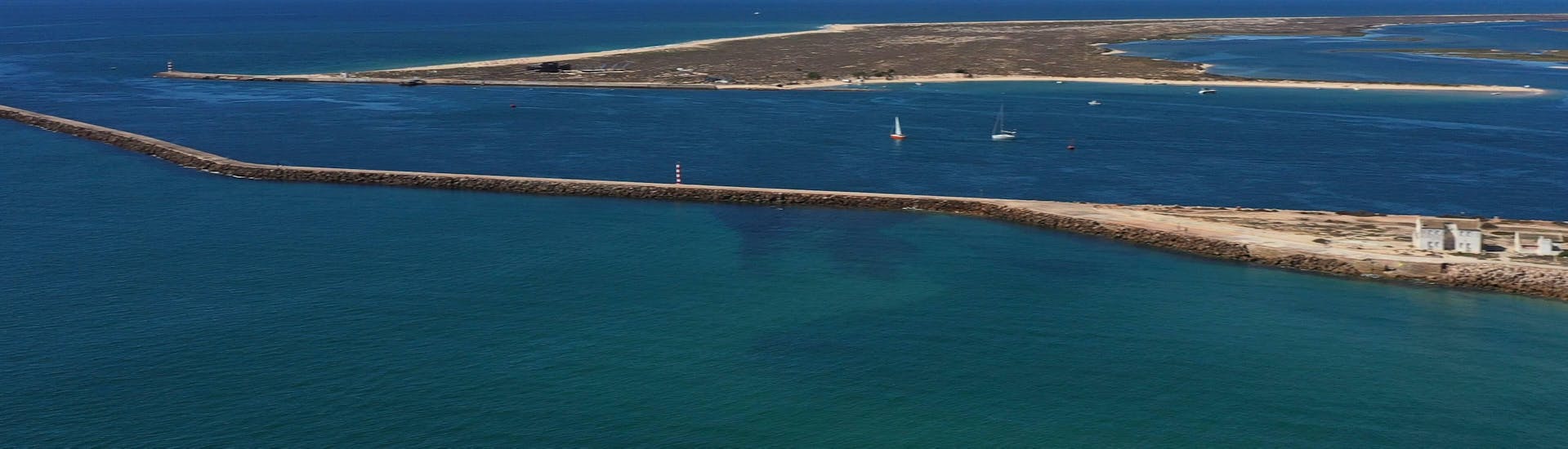 Wunderschöne blaue Lagune mit weißem Sand, die Ihr während der Bootsfahrt in Ria Formosa mit Wildlife Watching mit dem Anbieter Odyssey Tours sehen werdet.