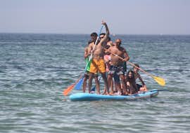 Location de Mega Stand Up Paddleboarding à Armação de Pêra avec Moments Watersports Algarve Une photo d'une famille s'amusant sur un Mega Stand Up Paddleboard à Armação de Pera loué chez Moments Watersports Algarve.