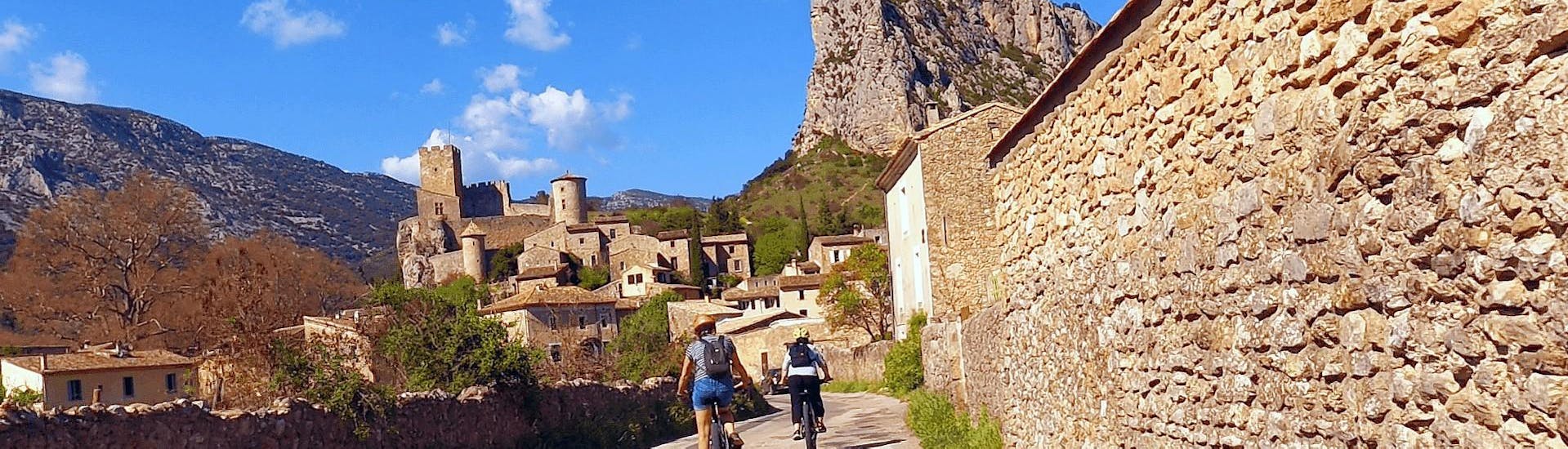 Deux touristes reviennent au village de Saint-Jean-de-Buèges grâce à la Location de VTT suspendu de Le Garrel Hérault.