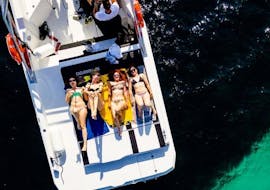 A group of friends laying on the boat and enjoying the sun during the boat trip to Capri with snorkeling with Capitano Ago.