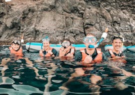 A group of people snorkel at Los Cristianos beach in Tenerife with Diving Atlantis. 