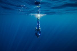 Un apnéiste confirmé se détend dans l'eau pendant sa formation FFESSM dans le lac d'Annecy avec Reda Apnea Annecy.