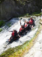 A group of participants sliding down a rock during the canyoning in the Alcantara with Sicilia Adventure.
