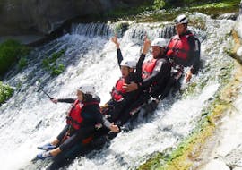 A group of participants sliding down a rock during the canyoning in the Alcantara with Sicilia Adventure.
