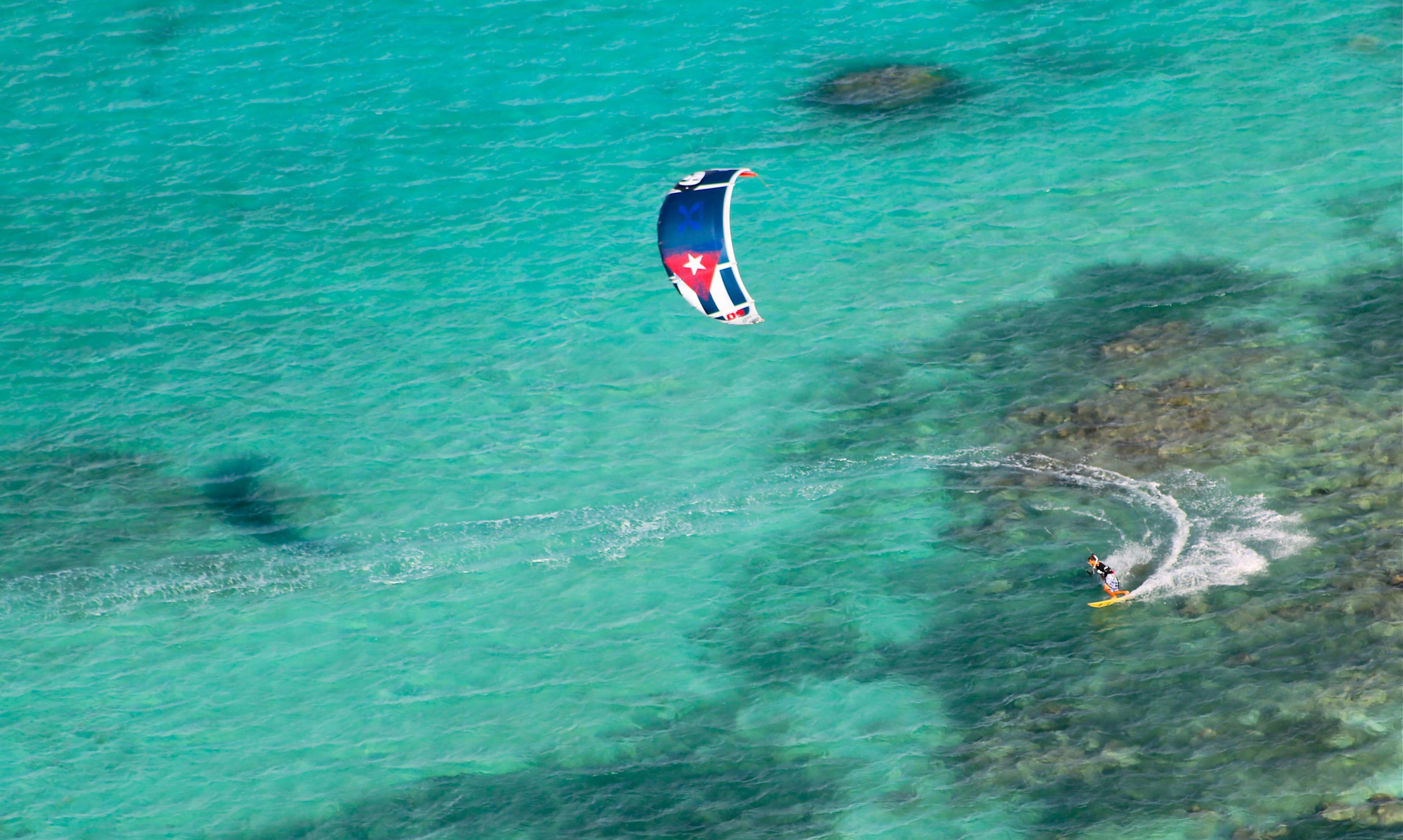 A person doing kitesurfing in blue water during a Private Kitesurfing Lessons in Les Saintes with the provider CBCM France. 