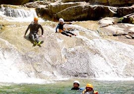People slide down a natural slide in the Chassezac Canyon with Cévèn'Adventure. 