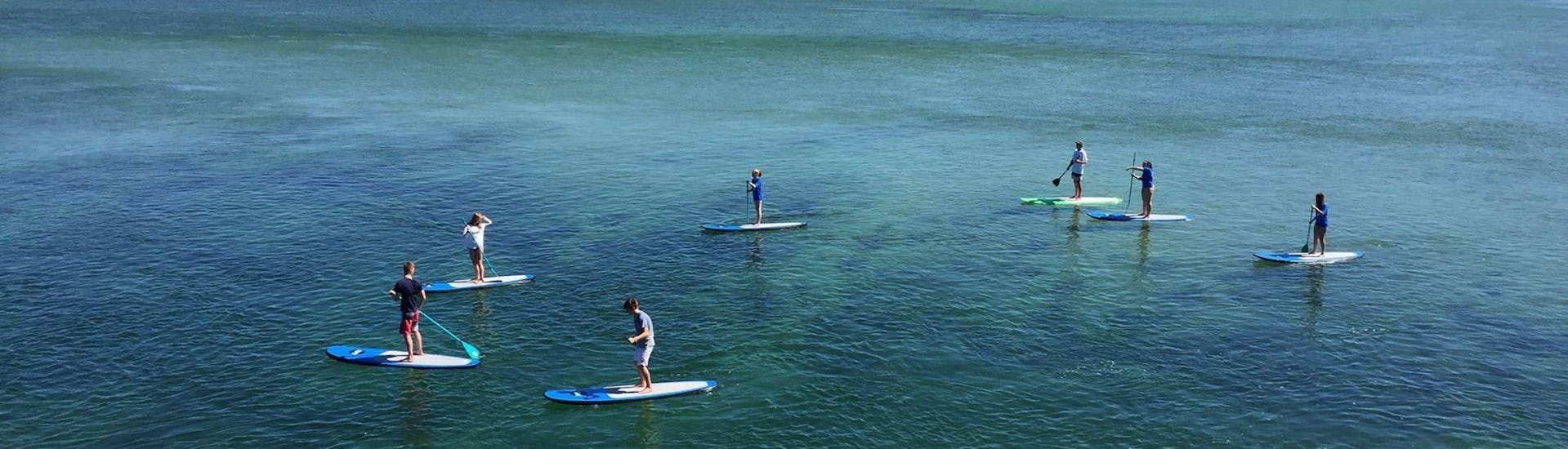 A group of people do a SUP route in La Lanzada with Waipia Surf School.