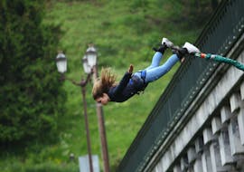 A girl is jumping in the air during the Bungee Jumping from Viaduc d'Arudy (35m) with Elastic Crocodil Bungee Pyrénées.
