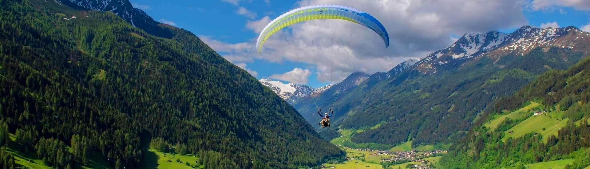Two people tandem paragliding in Innsbruck during the Panorama Flight with Paragliding Tirol.