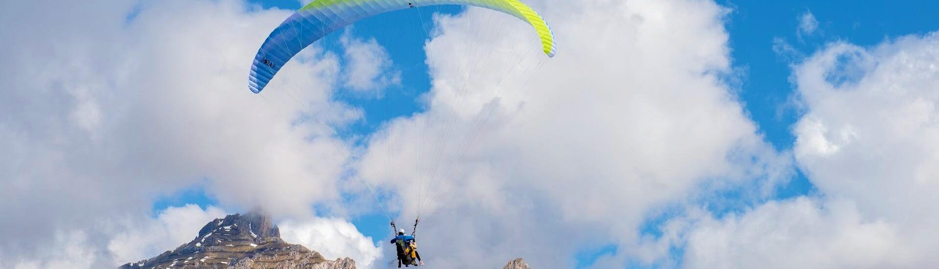 Two people who are tandem paragliding in Innsbruck with Paragliding Tirol are soaring high above the ground.