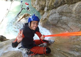 A young man is abseiling in Barbaira Canyon during a full day canyoning with Maglia Canyoning.
