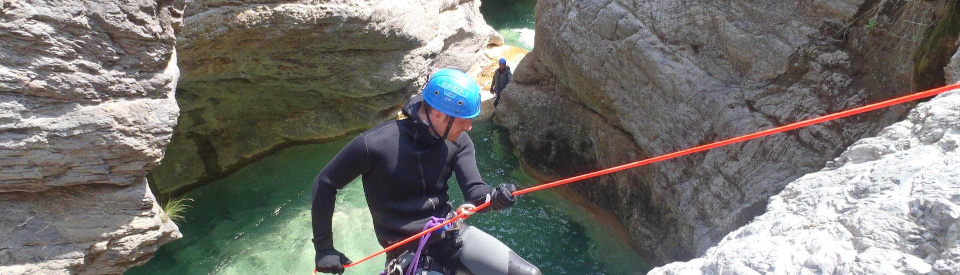 Un uomo si cala in corda doppia durante un canyoning avventura con Maglia Canyoning Val Roia.nel Canyon di Barbaira