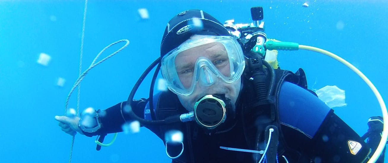 A divers looks at the camera while diving during his FFESSM Level 1 Diving Course in Saint-Tropez for Beginners.