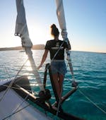 Une fille profite du coucher de soleil lors de la Balade en catamaran au coucher du soleil à l'île de l'Asinara avec Buriana Charter Stintino.