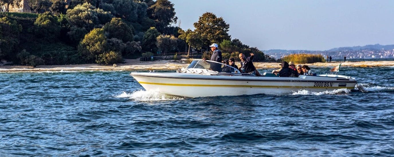I partecipanti si godono la nostra gita in barca sul lago di Garda lungo la penisola di Sirmione.