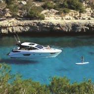A person paddle surfs whilst on a private boat trip to Formentera with Charteralia Ibiza.