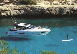 Eine Paddelsurferin auf einem privaten Bootsausflug nach Formentera mit Charteralia Ibiza.