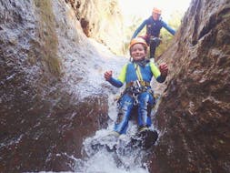 A girl sliding while canyoning in the Ribeira das Cales with Madeira Adventure Kingdom.