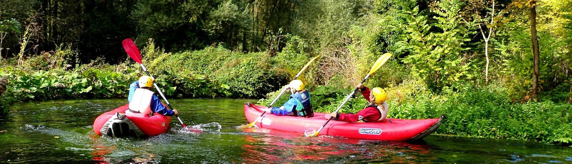 Un gruppo di amici si gode il paesaggio della Valnerina durante un giro in canoa sul fiume Corno con Rafting Umbria. 
