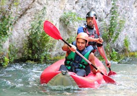 A boy faces the Corno river on board of his canoe followed by an experienced instructor during a canoeing tour on the Corno river with Rafting Umbria. 