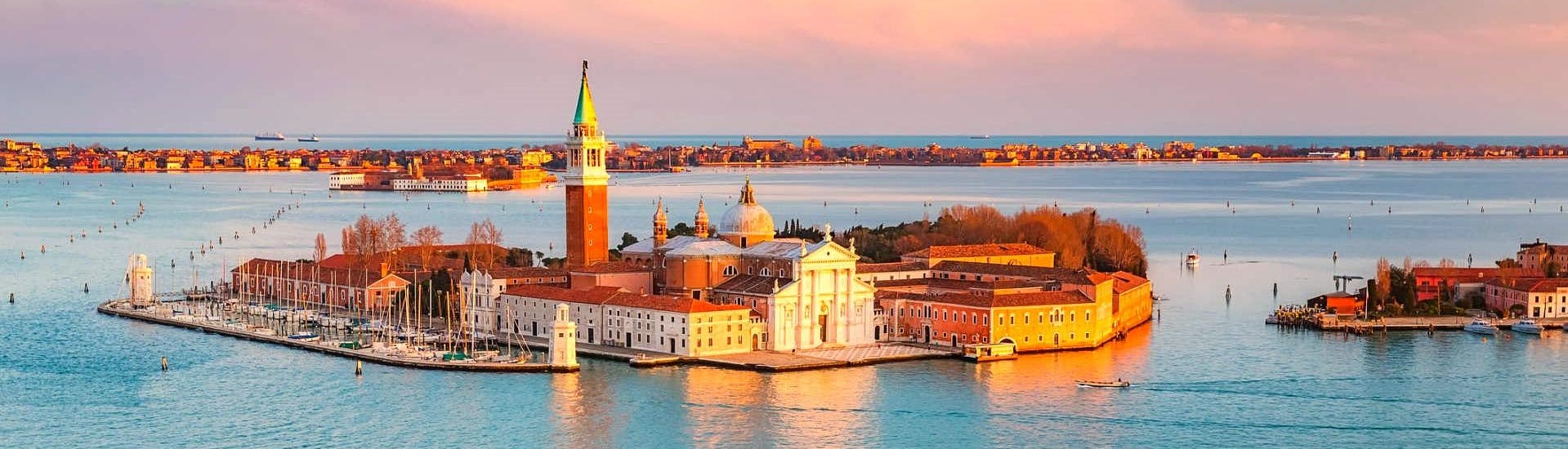 Vue sur l'île de San Giorgio Maggiore, qui peut être observée lors d'une balade en bateau privé le long des canaux vénitiens au coucher du soleil avec Venice Boat Experience.