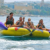 Un gruppo si diverte sul crazy sofa durante il Crazy Sofa a St George's Bay con Sun & Fun Watersports Malta.